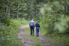 Mature Couple Walking A Forest Path