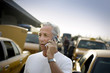 © Erickson Stock - Mature man talking on his cell phone in a car park.