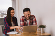 © bnenin - A beautiful young couple sitting at a Table and working on compu
