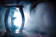 © zef art - Time concept. Silhouette of Hourglass clock and old vintage wood clock with arrow and smoke on dark background with hot yellow orange red blue cold back lighting, or symbols of time with copy space
