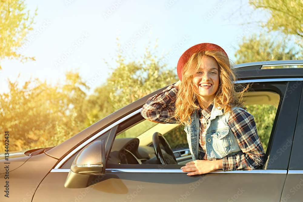 Young female driver in car on road trip