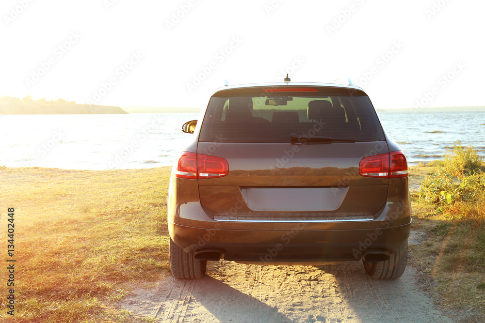 Car on parked river shore