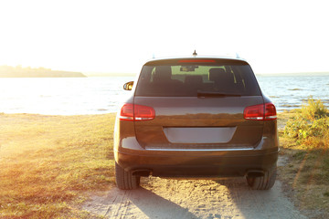 Car on parked river shore