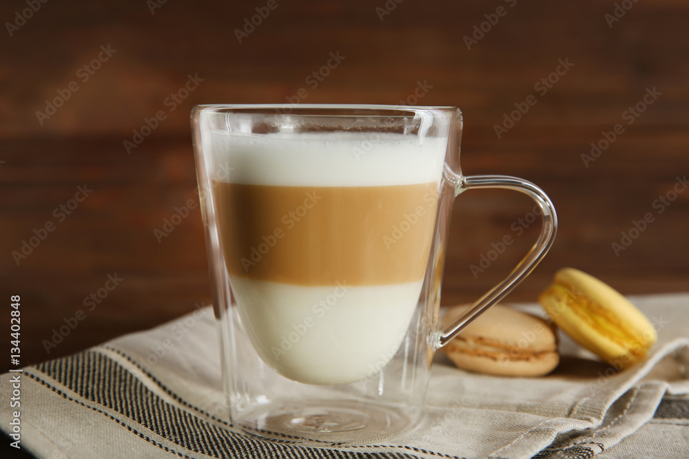 Cup of coffee with macaroons on wooden background