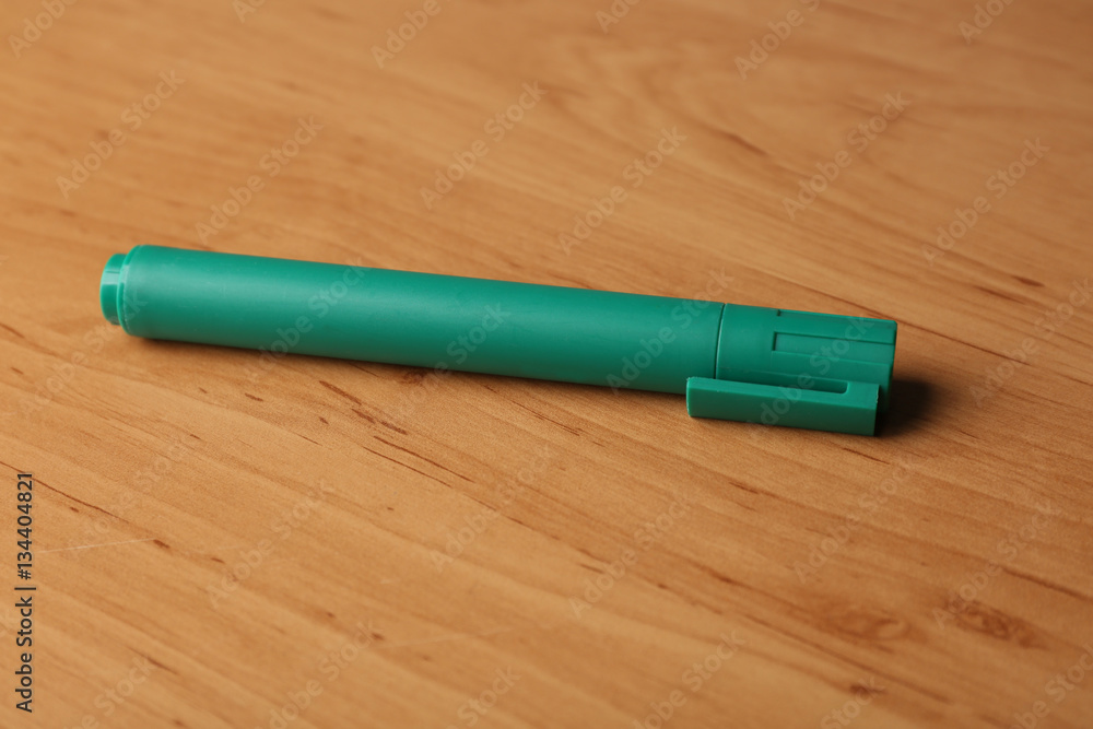 Green felt pen on wooden background