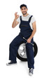 Young mechanic in uniform with spanner and wheel on white background