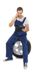 Wall Mural - Young mechanic in uniform with a clipboard on white background