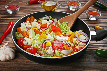 Wall Mural - Fresh vegetables in pan and wooden spatula on table closeup