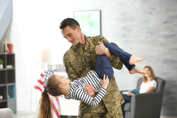 Canvas Print - Soldier in camouflage playing with his daughter at home