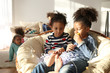 © Africa Studio - Two cute African girls sitting in armchair with lemon and garland at home