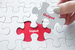 Close up of girl's hand placing the last jigsaw puzzle piece wit