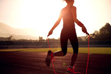 Young Woman Skipping Rope During Sunny Morning On Stadium Track
