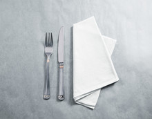 Blank White Restaurant Napkin Mockup With Knife And Fork, Isolated. Cutlery Near Clear Textile Towel Mock Up Template. Cafe Brand Identity Overlay Surface For Logo Design.