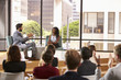 © Monkey Business - Man and woman talk in front of audience at business seminar