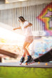 Girl on rollerblades. Young woman on blurred background. Ride with grace.