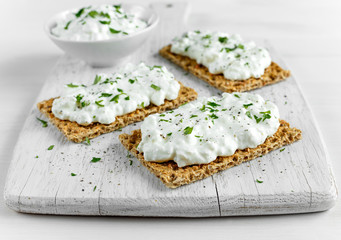 Wall Mural - Homemade Crispbread toast with Cottage Cheese and parsley on white wooden board.