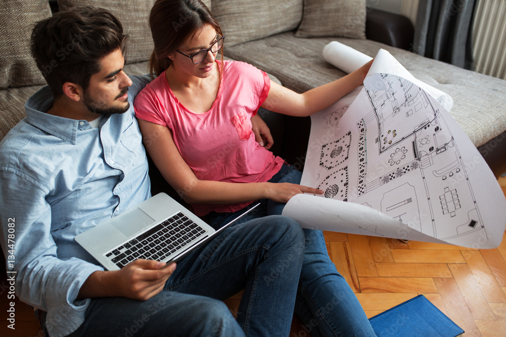 Young couple examining blueprints of they new house.Moving house concept.