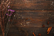Wooden table with dry herbs flat lay free space. Top view on old rustic background with herbarium and spices, copy space for text. Craft, alternative medicine, magic concept