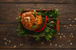 Baked stuffed pumpkin with fresh green flat lay. Top view on kitchen table with full prepared squash, Seasonal Halloween menu, vegetarian cuisine, healthy food concept