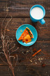 Sweet orange pumpkin tart with bright turquoise cup of milk flat lay. Top view on pretty served sweet dessert with with drink in rustic style. Coziness,comfort, pleasure, evening concept