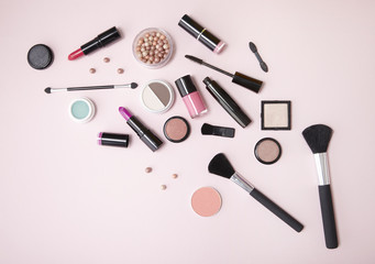 make up products arranged on a light pink background