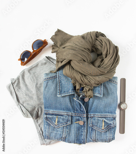 Zdjęcie XXL Stylowy zestaw kobiecych ubrań. Kobieta / dziewczyna strój na białym tle. Niebieska kurtka dżinsowa, szary t-shirt, szalik, zegarek i retro okulary przeciwsłoneczne. Płaski lay, widok z góry