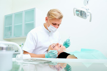 Male dentist with the patient in  dental office.