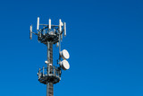 Fototapeta Góry - Communication tower against crystal clear blue sky background