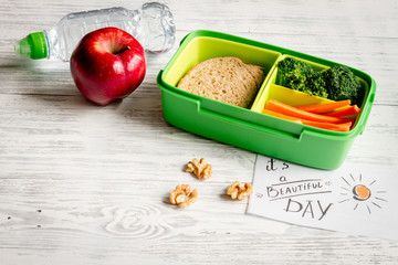 lunch box for kid with fresh vegetables on wooden background