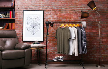 Casual stylish shirts on hanger stand in room