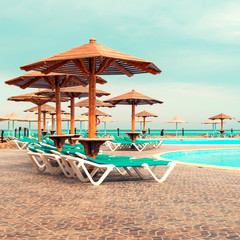 Wall Mural - Sunbeds and umbrella around the pool on sunny day