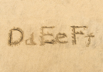 Wall Mural - alphabet letters handwritten in sand on beach