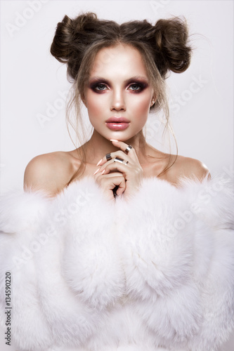 Naklejka na meble Beautifful european brunet woomen with gloss clean healfy skin, glooss shiny pastel pink lipstik and with trendy fashion hairstyle in white fluffy fur coat