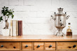 old shelf with a book and a flower and a kettle on a wall background