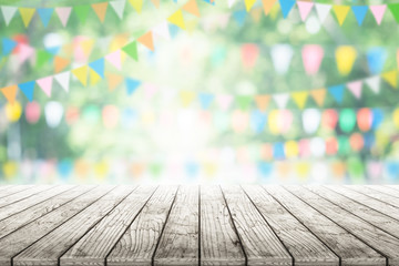 Empty wooden table with party in garden background blurred.