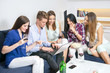 © Bojan - Group of cheerful young people looking at the laptop together and smiling at home.