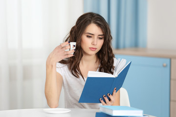 Wall Mural - Beautiful young woman reading book at home