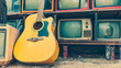 © Aris Suwanmalee - Classic guitar laying down on retro television in vintage style.