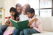 © wong yu liang - indian family reading a book together