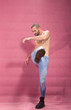© HD92 - young man kicking boots, pink background, shirtless