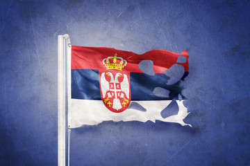 Wall Mural - Torn flag of Serbia flying against grunge background