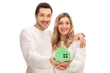 Poster - Joyful couple holding a model house