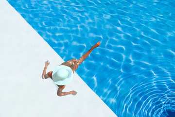 Wall Mural - beautiful tanned sporty slim woman relaxing in swimming