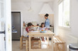 © Monkey Business - Brother and sister doing homework in kitchen while mum cooks