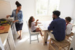 © Monkey Business - Dad helping kids with homework and mum cooks, elevated view