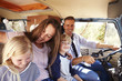 © Monkey Business - Family sitting at the front of their camper van, dad driving