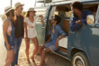 © Monkey Business - Friends on a road trip hanging out by their camper van