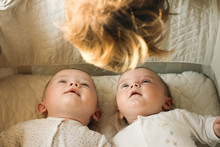 Twins Lay In Cot And Persons Head 