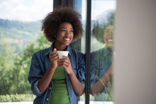African American Woman Drinking Coffee Looking Out The Window