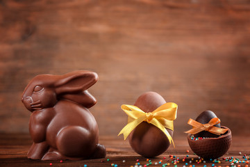 Wall Mural - Chocolate Easter bunny with eggs on wooden background